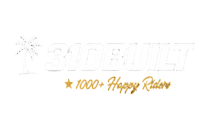 A white graphic on a white background featuring the text 'SIDBUILT' in a light gray outlined font with a small palm tree icon, and gold script text below reading '★ 1000+ Happy Riders'.
